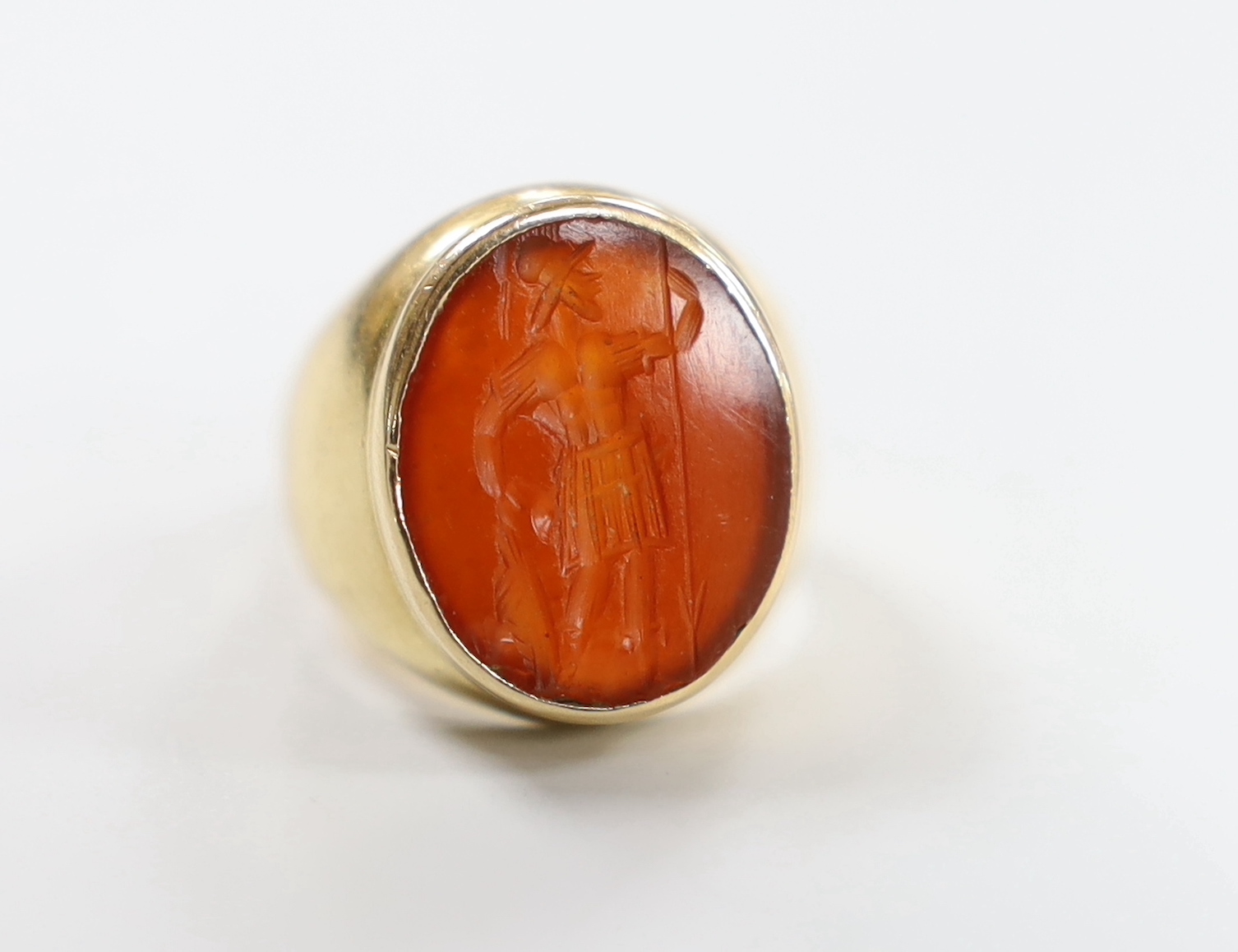 An antique yellow metal intaglio carnelian set ring, carved with a Roman soldier, size F/G, gross weight 11.1 grams.